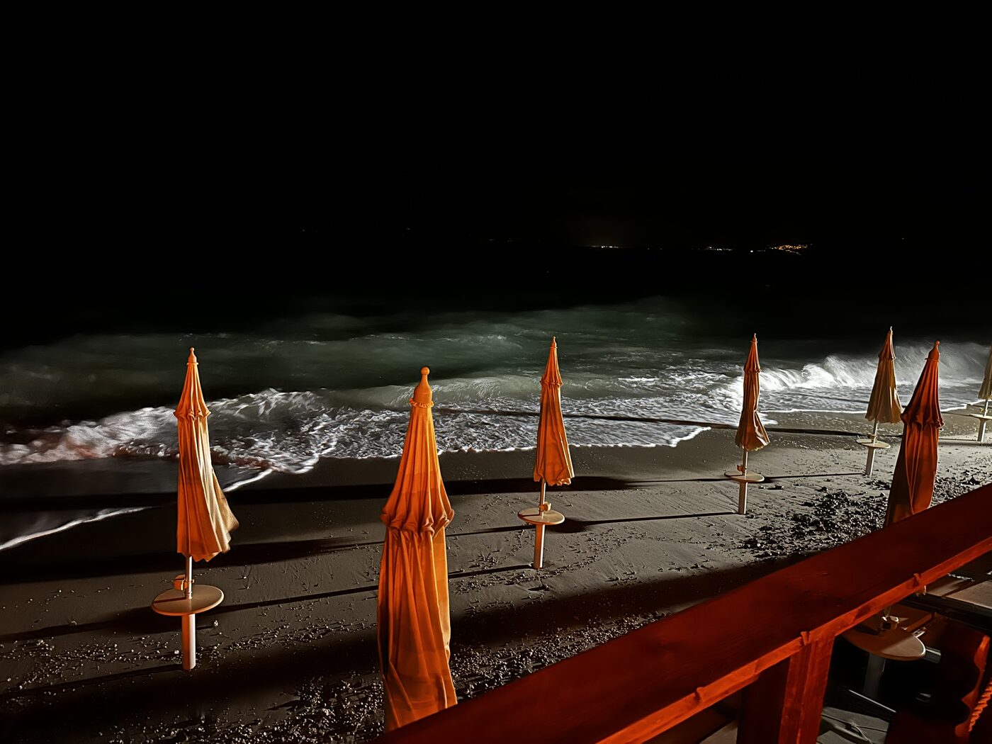 Beach umbrellas and waves under the night sky
