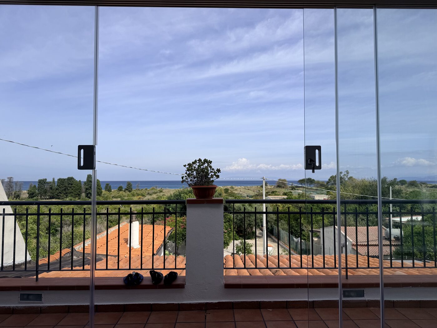 Sea and hills viewed through glass doors