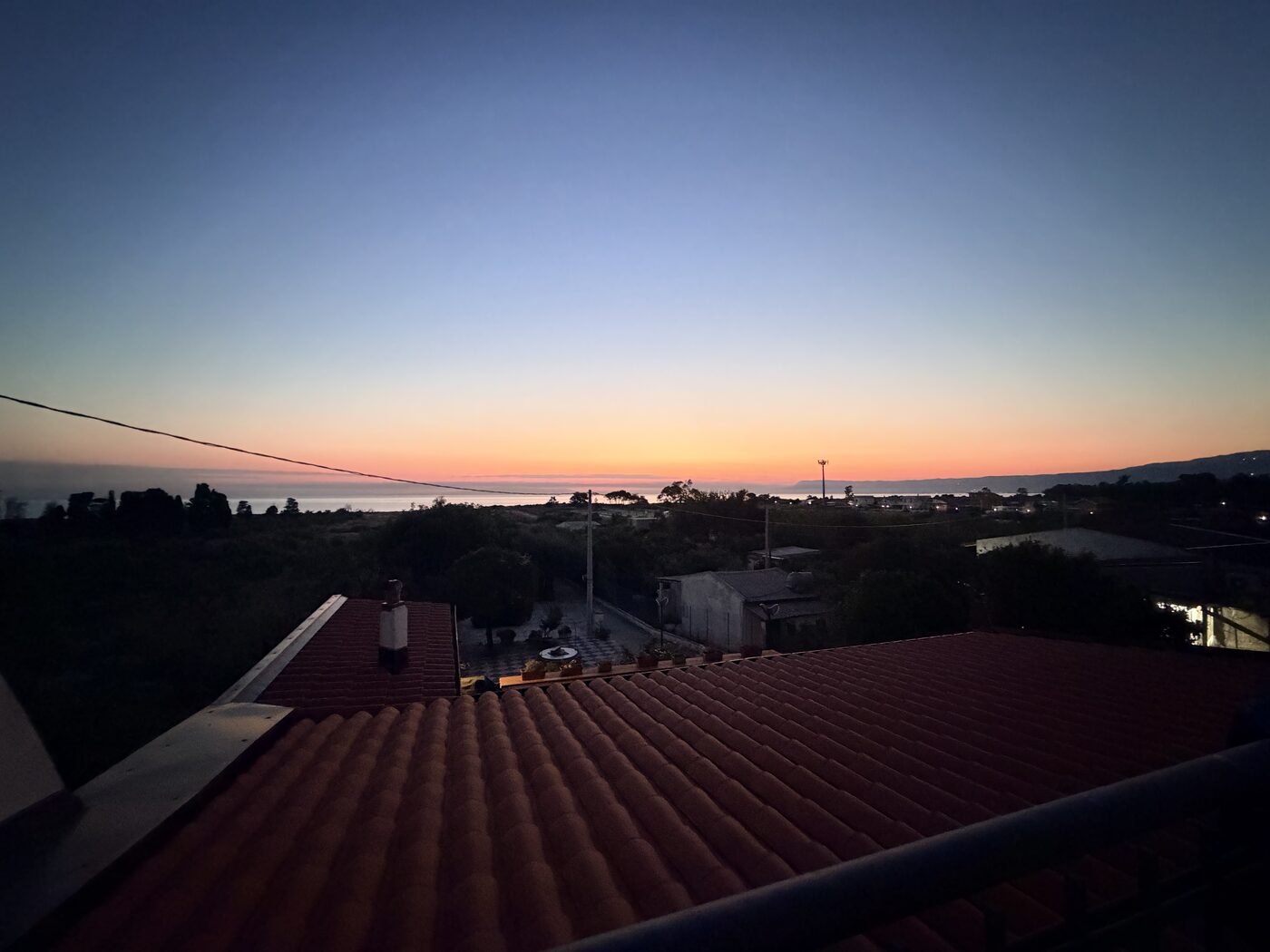 Dawn sky above red-tiled rooftops